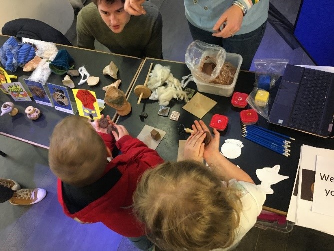 children with paints and craft supplies at a table